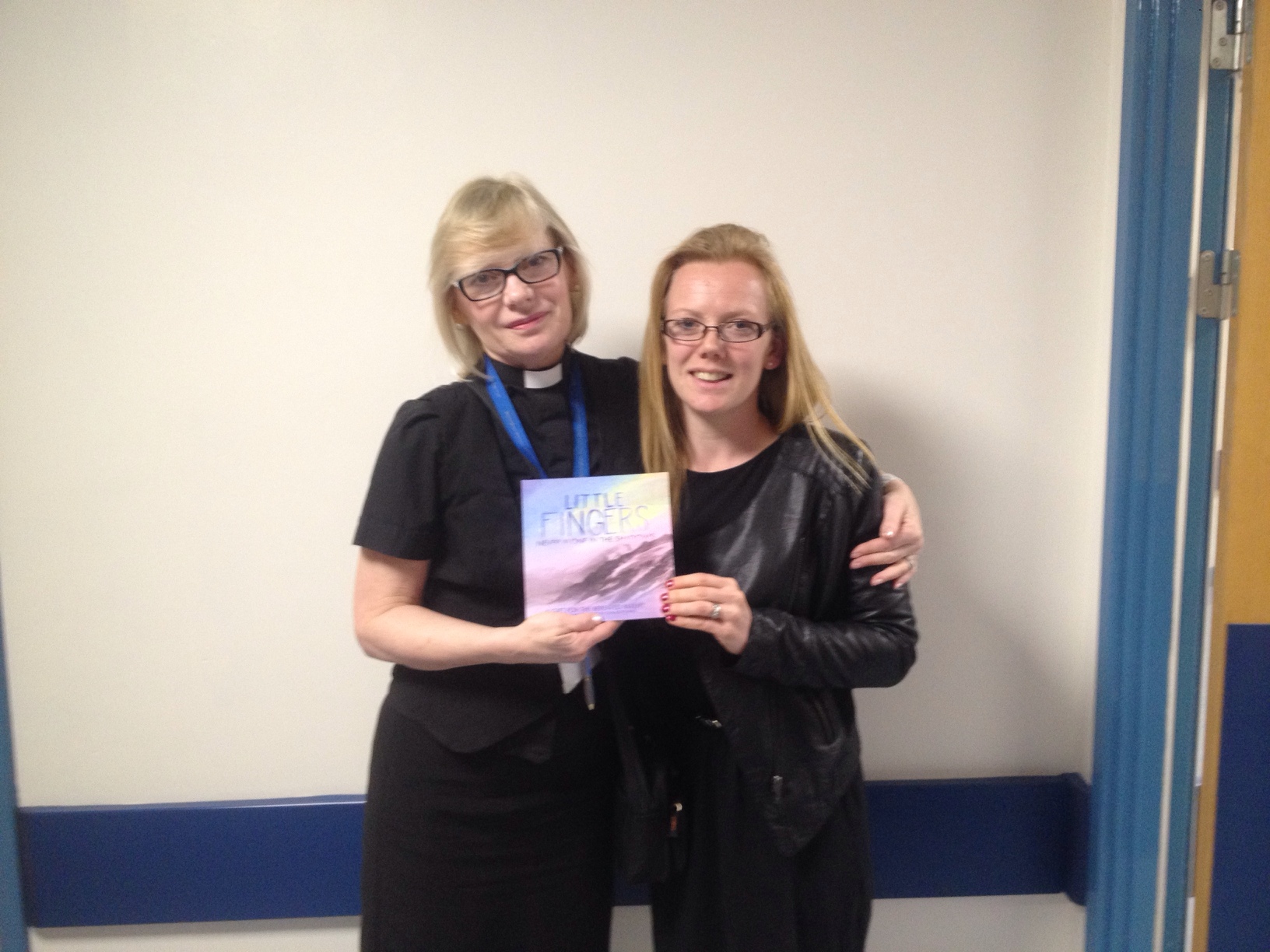 Picture of Charlotte handing Little Fingers books over to denise